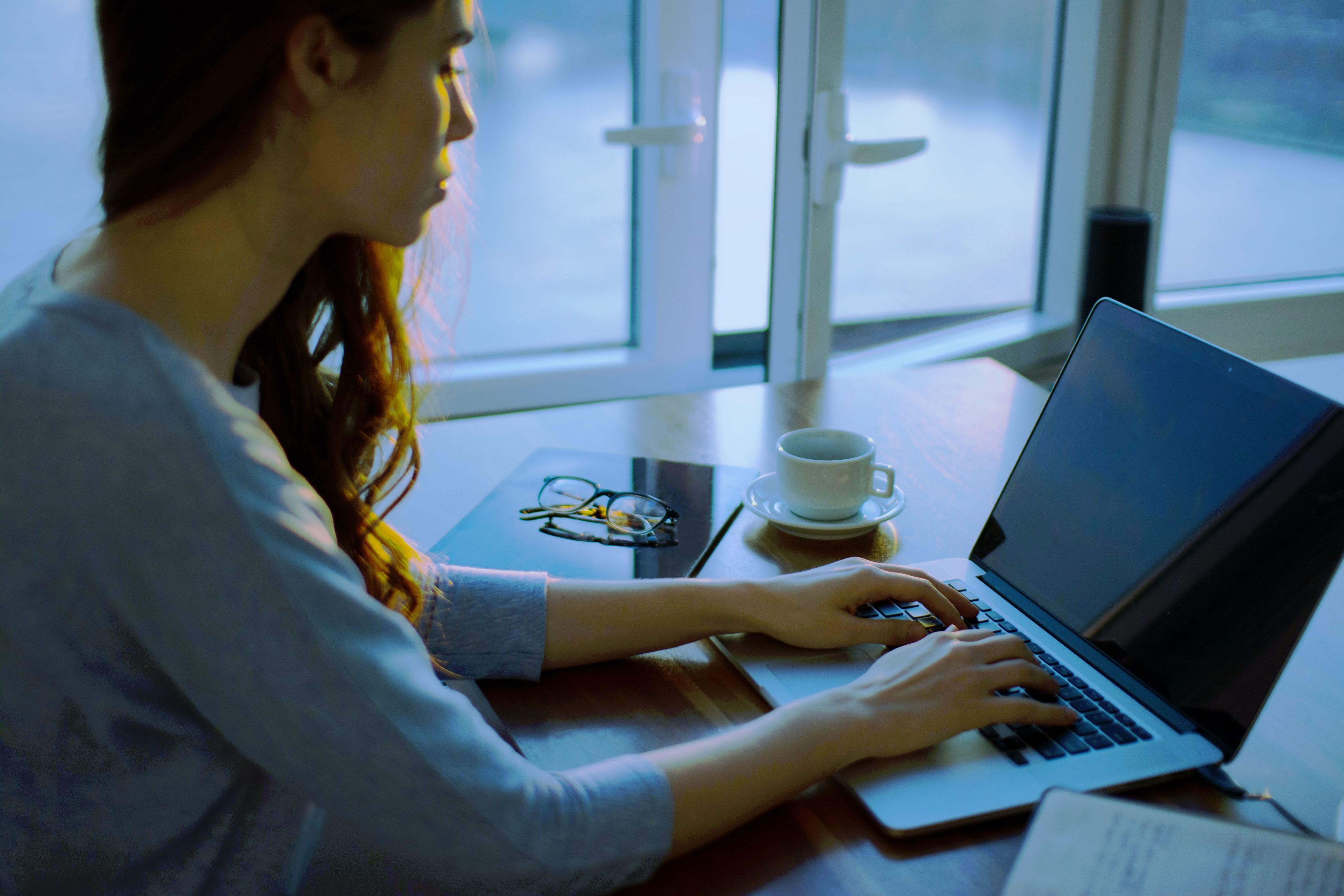 woman sitting beside table using laptop